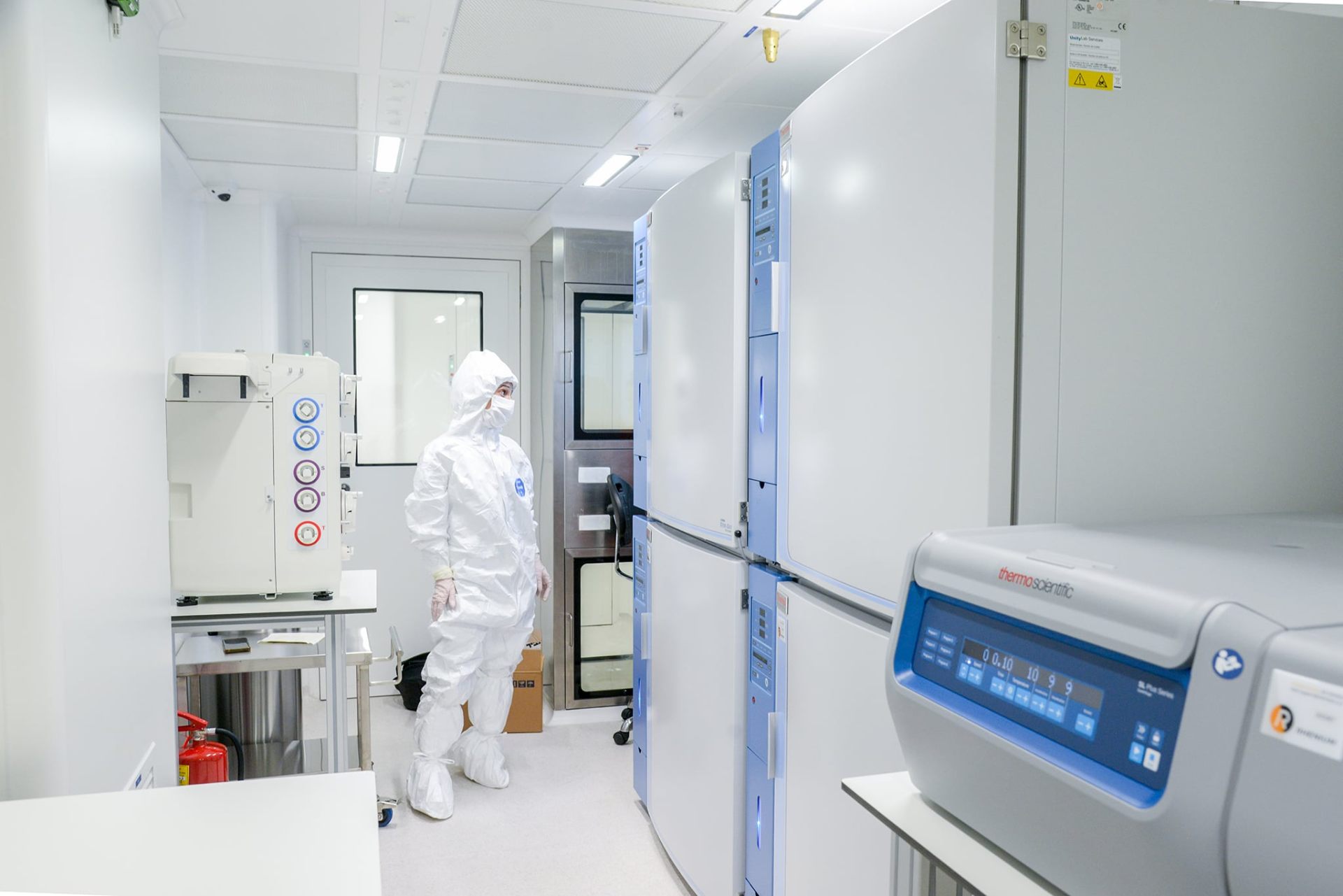 Technician in cleanroom suit working inside a processing unit